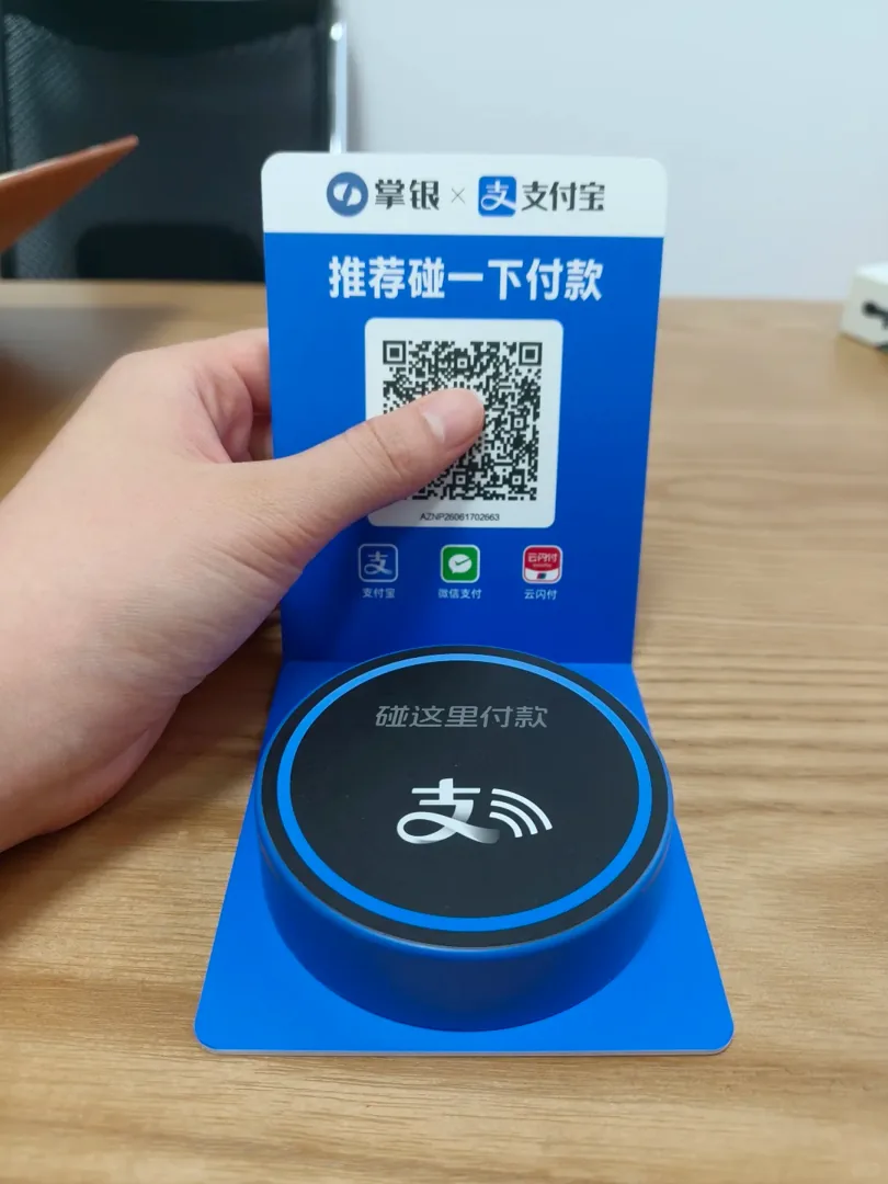 Figura 2: expositor con código QR y receptor de pago por aproximación de Alipay